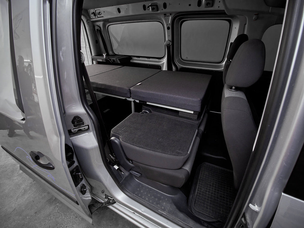 COMO Campingbox mit Einzelbett, aufgebaut im VW Caddy Maxi – Blick durch die geöffnete Schiebetür
