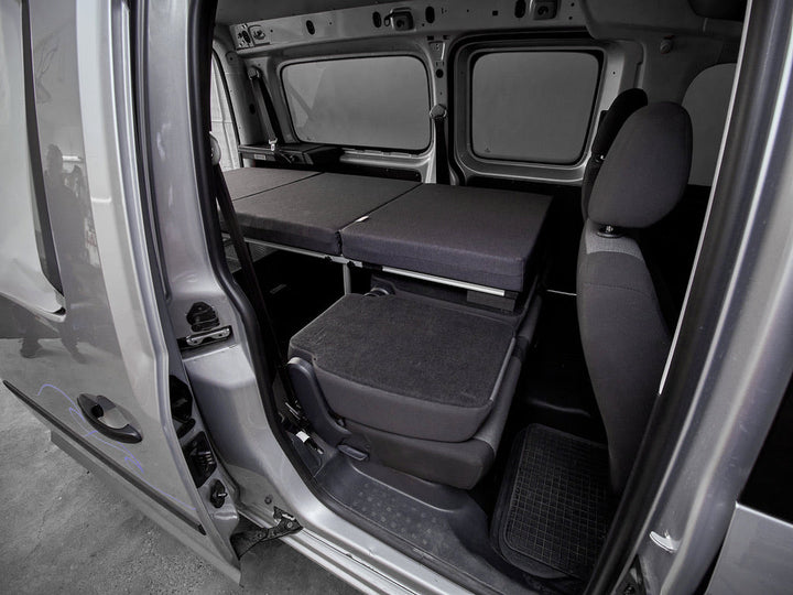 COMO Campingbox mit Einzelbett, aufgebaut im VW Caddy Maxi – Blick durch die geöffnete Schiebetür
