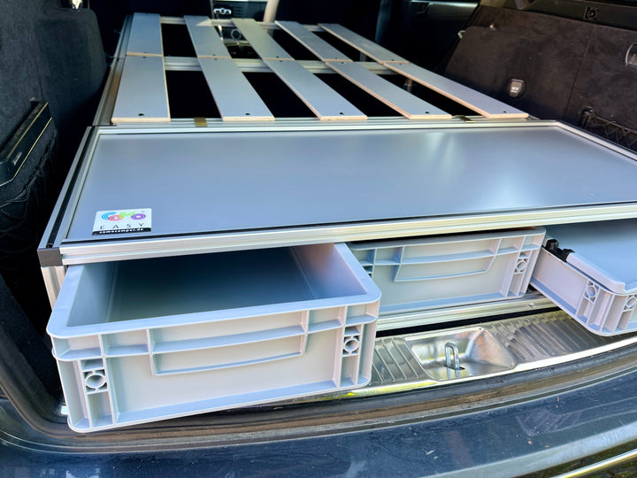 Mercedes C-Klasse mit eingebauter COMO Easy 15 – Blick durch die geöffnete Heckklappe auf die Euroboxen ohne Matratze
