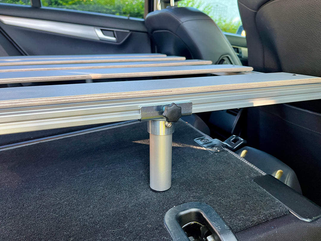 Seitenansicht des eingebauten Betts der Campingbox COMO Easy 15 in der Mercedes C-Klasse mit Detailansicht des Stützfußes
